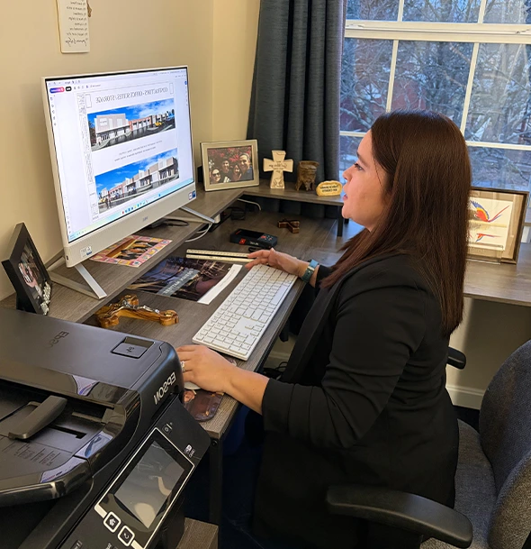 Woman reviews residential architecture designs on a computer screen.